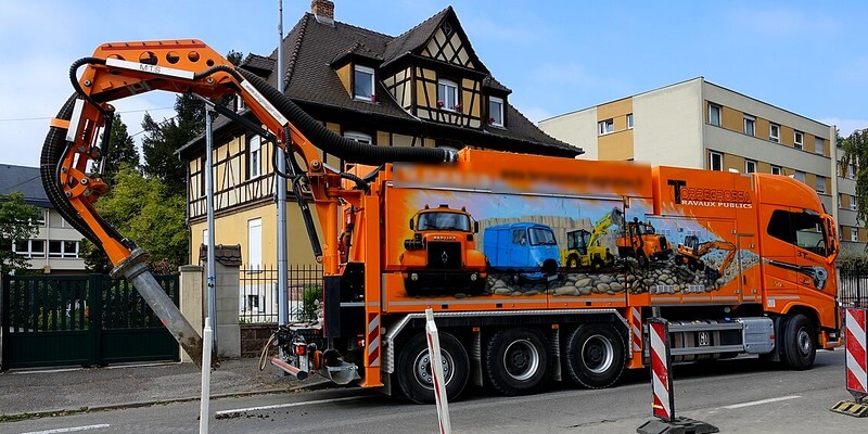 Camion aspirateur orange pour des travaux de terrassement