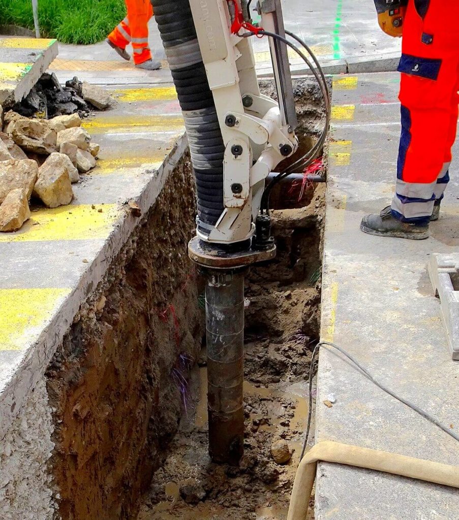 Travaux de terrassement sur la route avec une excavatrice aspiratrice