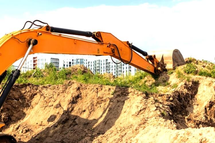Une excavatrice creuse une fosse de fondation pour la construction d'un bâtiment